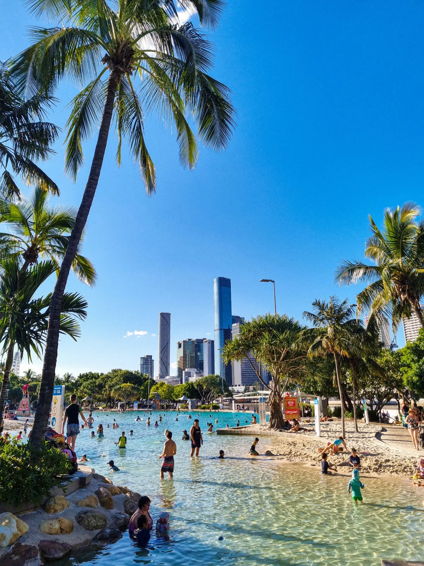 Lagoon beach with palms and city towers